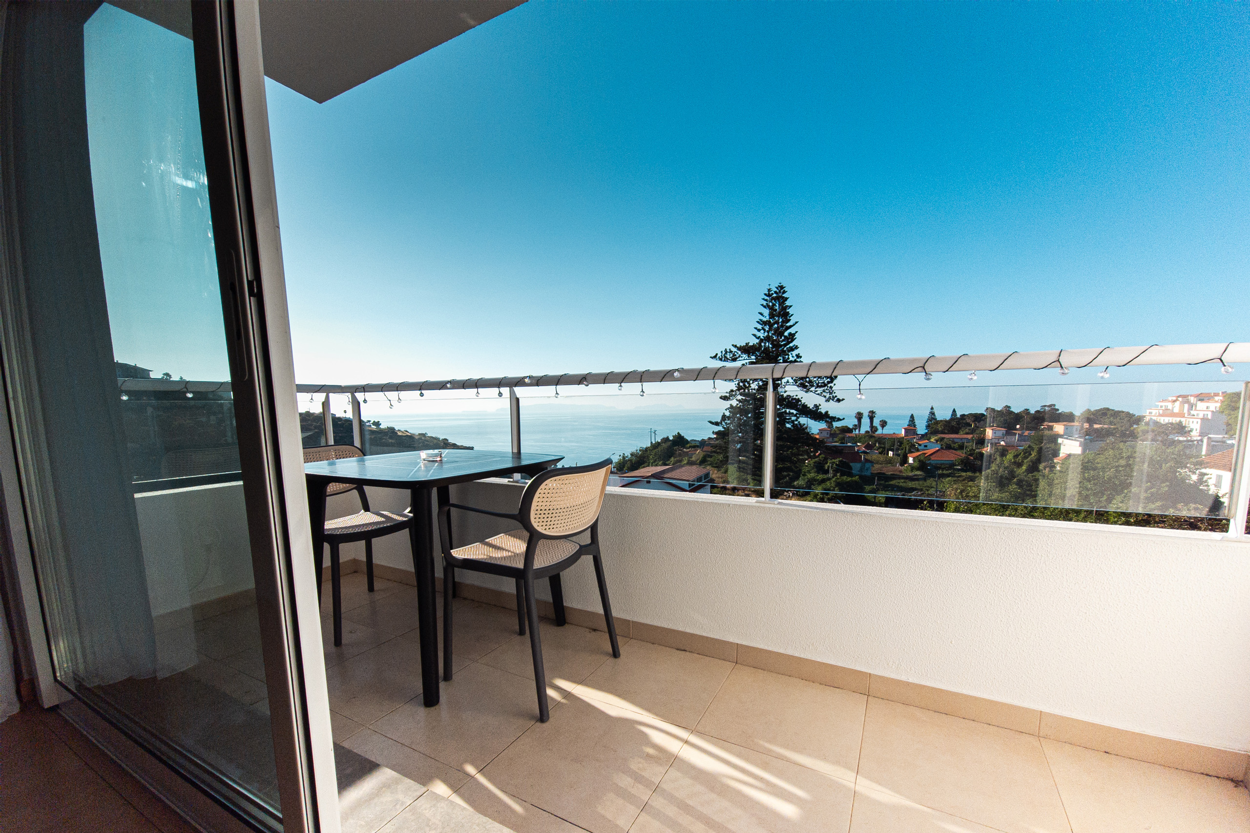 Widok z balkonu mieszkania na okolicę i ocean, spokojna przestrzeń do wypoczynku.
