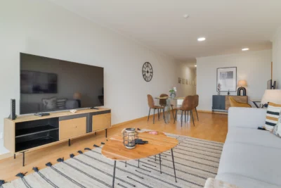 Salon ze Smart TV, stołem jadalnianym i wyjściem na balkon z widokiem.