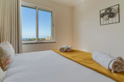 Widok z sypialni głównej na ocean i okolicę Caniço, jasne wnętrze.